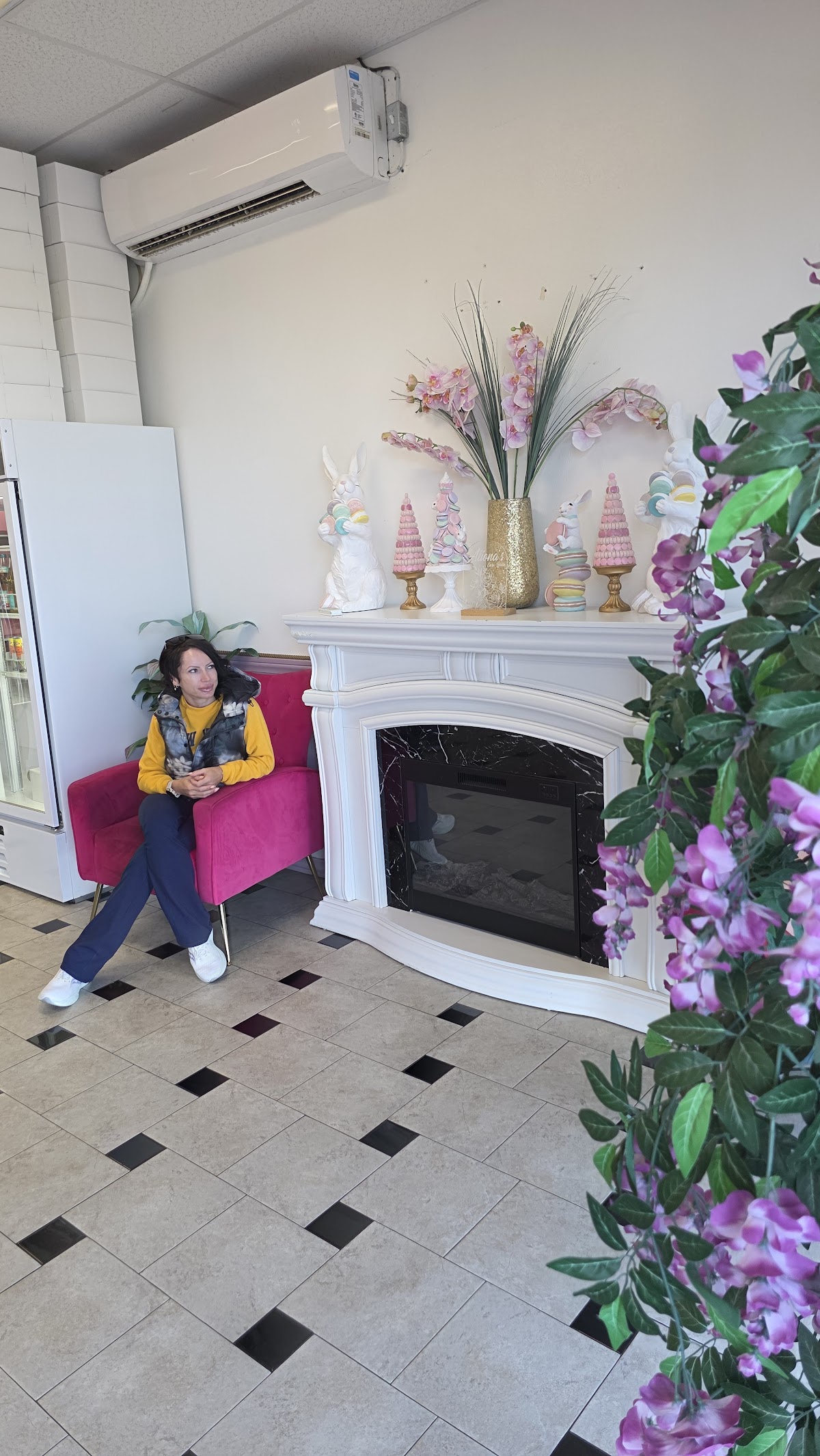 The cozy seating corner with a fireplace and pastel decor inside Aliona's Euro Bake
