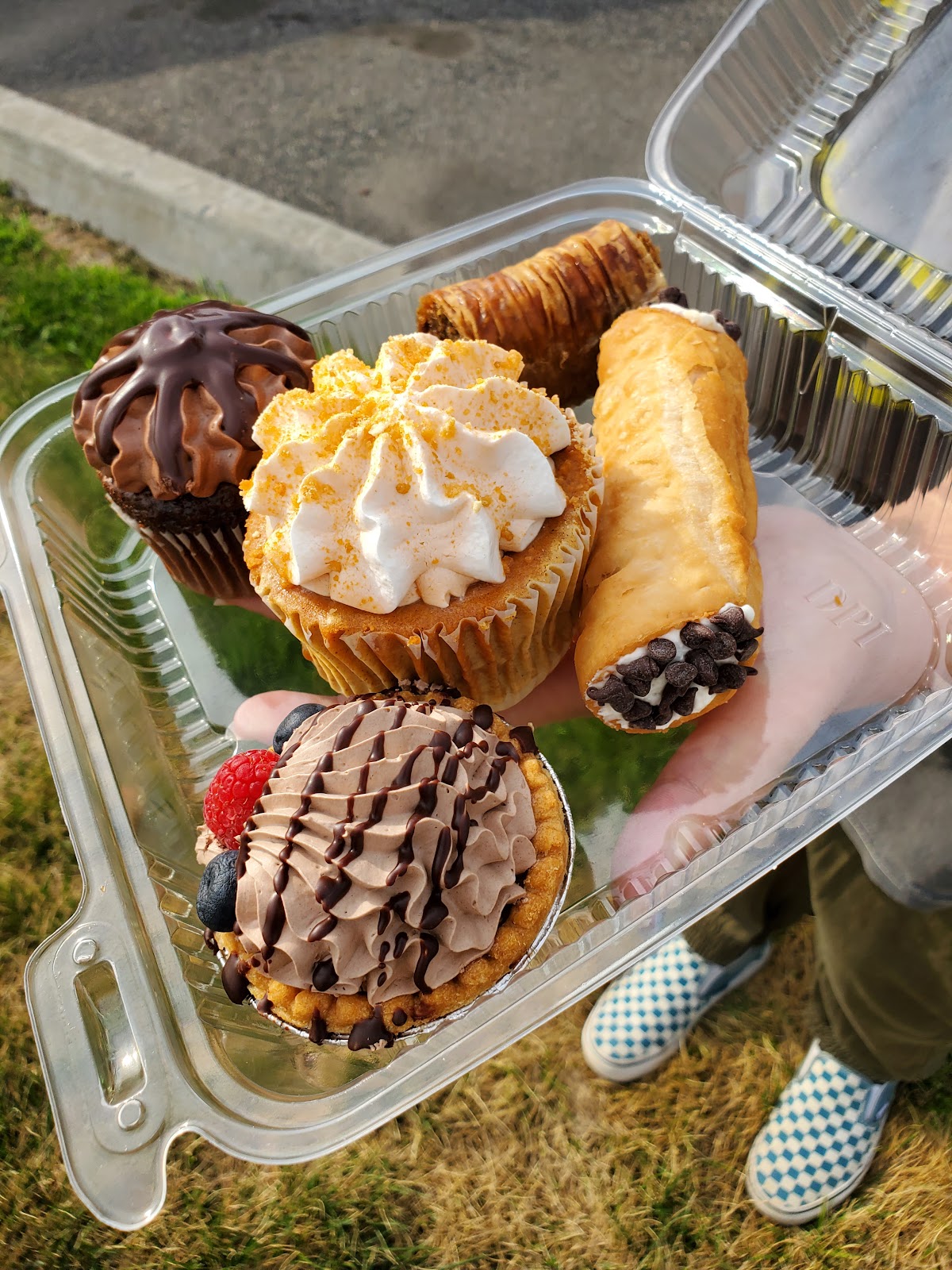 A takeout box of cannoli, cupcakes and pastries from Aliona's Euro Bake